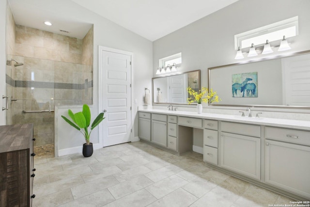 bathroom with a shower stall, double vanity, and lofted ceiling