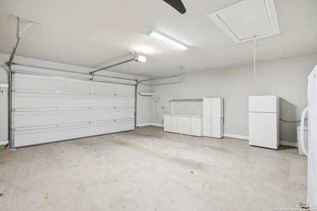 garage with freestanding refrigerator and a garage door opener