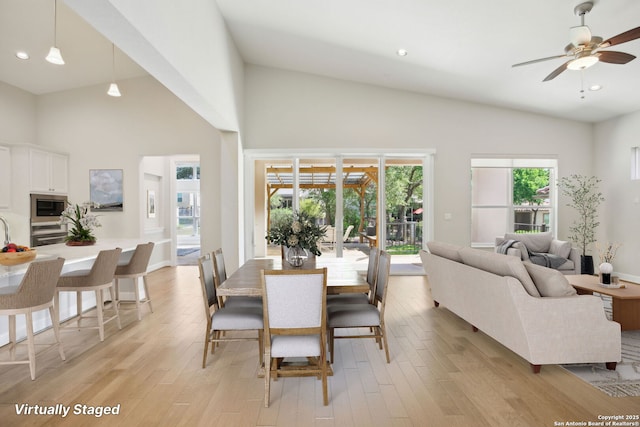 dining area featuring a ceiling fan, high vaulted ceiling, light wood-type flooring, and recessed lighting
