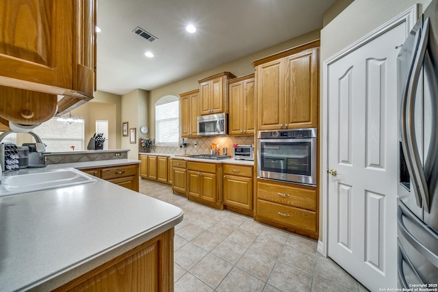 438 Chimney Tops, San Antonio, TX 78260 - kitchen featuring stainless steel appliances, decorative backsplash, light tile patterned flooring, a sink, and light countertops