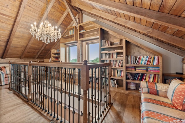 sitting room with wood ceiling, wood finished floors, a chandelier, and an upstairs landing