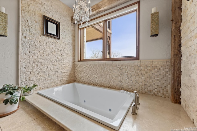 full bathroom featuring a chandelier and a whirlpool tub
