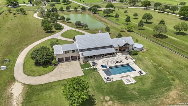 drone / aerial view of a nearby body of water and a pool area