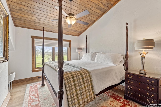 bedroom featuring wooden ceiling, vaulted ceiling, wood finished floors, baseboards, and a ceiling fan