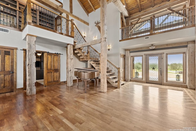 entrance foyer featuring high vaulted ceiling, stairs, wood finished floors, wood ceiling, and baseboards