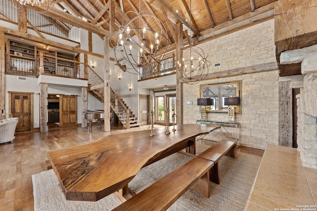 dining space with high vaulted ceiling, wooden ceiling, hardwood / wood-style flooring, a chandelier, and beam ceiling