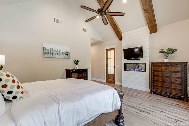 bedroom with light wood-style flooring, beamed ceiling, high vaulted ceiling, baseboards, and a ceiling fan