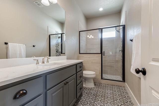 full bathroom with a stall shower, vanity, and toilet