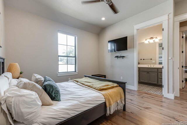 bedroom with light wood finished floors, a sink, recessed lighting, baseboards, and ensuite bathroom