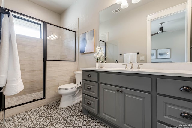 bathroom featuring toilet, a shower stall, a ceiling fan, and vanity