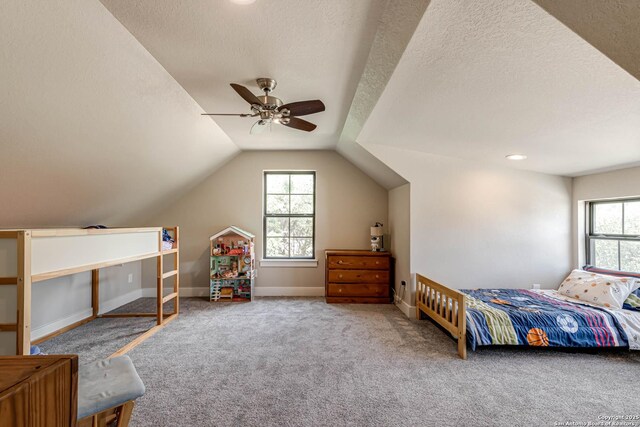 bedroom featuring carpet floors, multiple windows, a ceiling fan, vaulted ceiling, and a textured ceiling