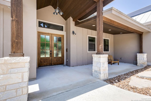 view of exterior entry with french doors and board and batten siding