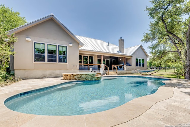 outdoor pool featuring ceiling fan, a patio area, and an in-ground hot tub