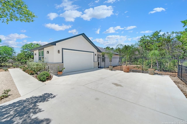 view of side of home featuring fence, stucco siding, stone siding, driveway, and an attached garage