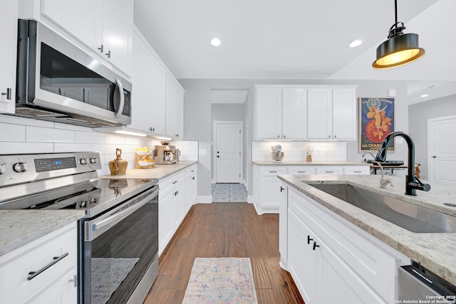 kitchen featuring stainless steel appliances, a sink, decorative backsplash, recessed lighting, and white cabinetry