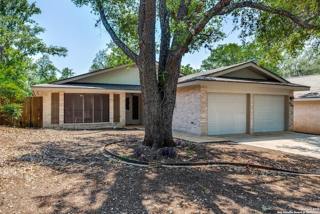 9007 Luzita Ln, San Antonio, TX 78230 - ranch-style home with brick siding, concrete driveway, fence, and an attached garage