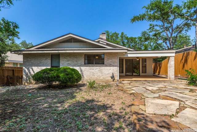 9007 Luzita Ln, San Antonio, TX 78230 - back of property featuring brick siding, fence, a chimney, and a patio