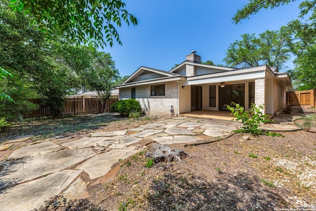 9007 Luzita Ln, San Antonio, TX 78230 - back of house featuring a patio, a fenced backyard, a chimney, brick siding, and a ceiling fan