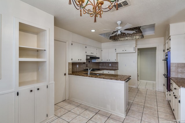 9007 Luzita Ln, San Antonio, TX 78230 - kitchen with under cabinet range hood, tasteful backsplash, a peninsula, white cabinetry, and ceiling fan