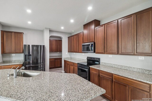 15006 Tethys Way, San Antonio, TX 78245 - kitchen with appliances with stainless steel finishes, a sink, arched walkways, recessed lighting, and light stone countertops