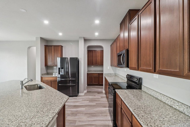 15006 Tethys Way, San Antonio, TX 78245 - kitchen with appliances with stainless steel finishes, arched walkways, a sink, recessed lighting, and light stone counters