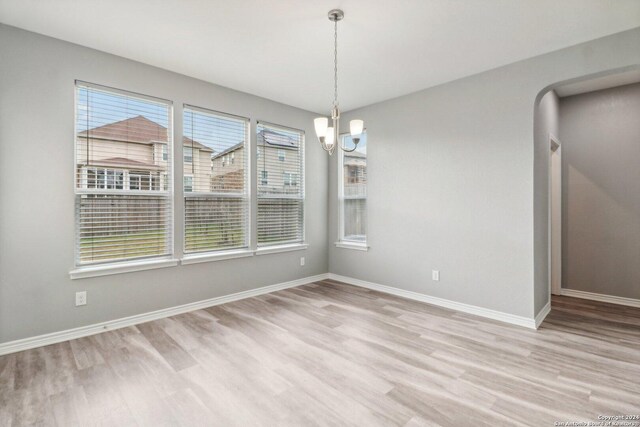 15006 Tethys Way, San Antonio, TX 78245 - unfurnished dining area with wood finished floors, a chandelier, and baseboards