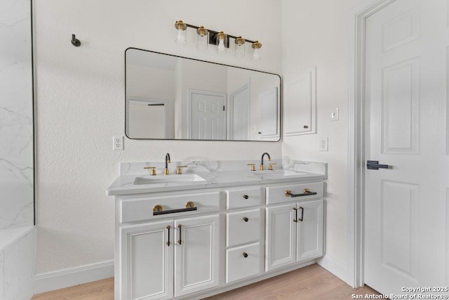 8651 Eagle Peak, Helotes, TX 78023 - bathroom featuring baseboards, wood finished floors, and double vanity