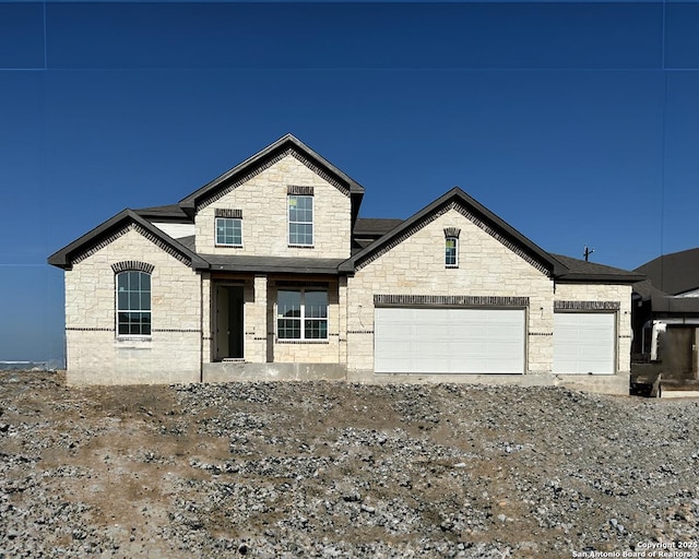 164 Annette Dr, Castroville, TX 78253 - french country inspired facade featuring stone siding, driveway, an attached garage, and roof with shingles