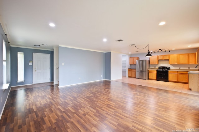 unfurnished living room with light wood-style flooring, recessed lighting, crown molding, and baseboards