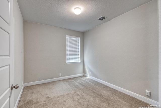 carpeted spare room with a textured ceiling and baseboards