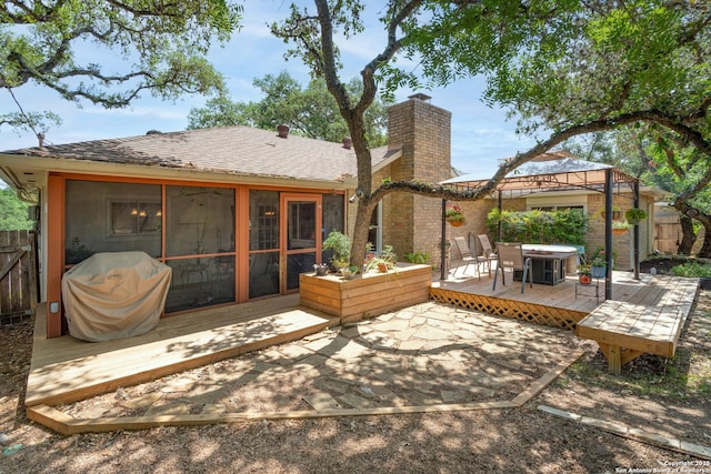 8423 Rolling Stone, San Antonio, TX 78254 - rear view of property with a chimney, a deck, fence, and a sunroom