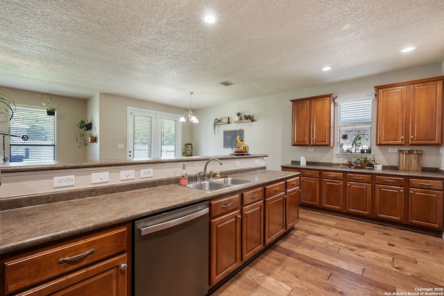 208 Cold Riv, Boerne, TX 78006 - kitchen featuring stainless steel dishwasher, a sink, a textured ceiling, light wood-style floors, and brown cabinets