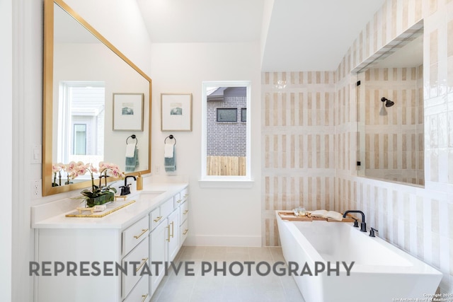 186 Lacey Oak, Castroville, TX 78009 - full bathroom with a soaking tub, tile patterned flooring, vanity, baseboards, and a tile shower