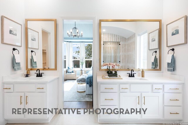 186 Lacey Oak, Castroville, TX 78009 - ensuite bathroom featuring a chandelier and two vanities