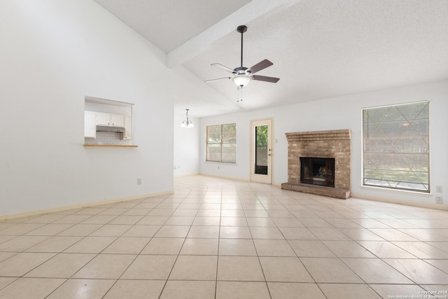 unfurnished living room with beamed ceiling, ceiling fan, a fireplace, light tile patterned floors, and high vaulted ceiling
