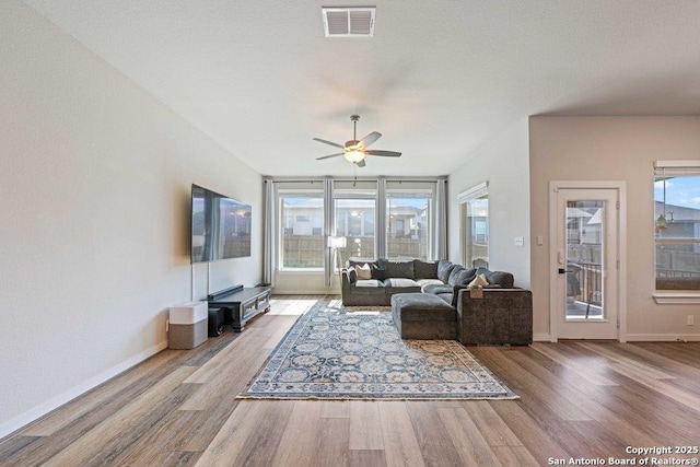 living area with wood finished floors, ceiling fan, and baseboards