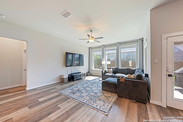 living room featuring wood finished floors, ceiling fan, and baseboards