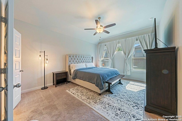bedroom featuring baseboards, light colored carpet, lofted ceiling, and ceiling fan