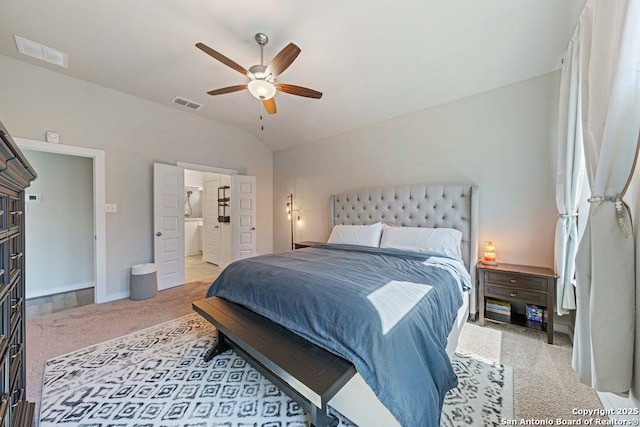 carpeted bedroom with vaulted ceiling, ceiling fan, baseboards, and ensuite bath