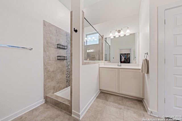full bath with walk in shower, tile patterned floors, vanity, and baseboards