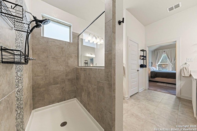 ensuite bathroom with walk in shower and tile patterned floors
