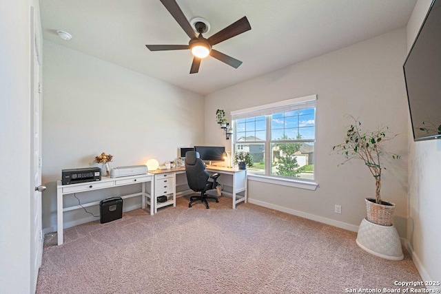 carpeted home office with a ceiling fan and baseboards