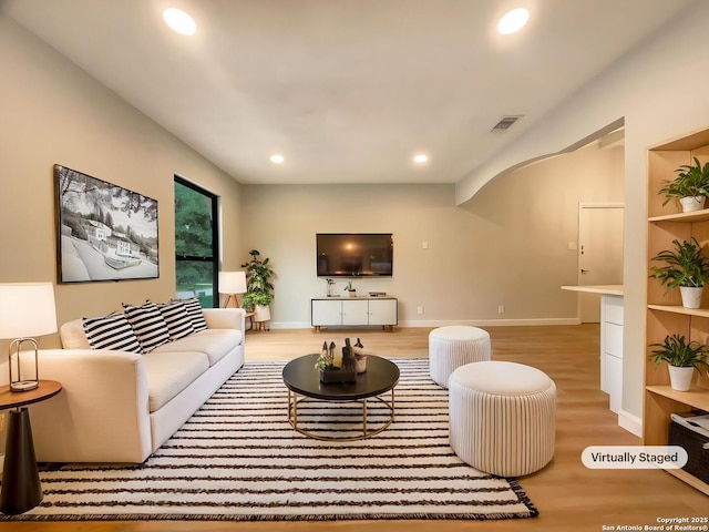 living room with wood finished floors, recessed lighting, and baseboards