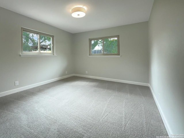 carpeted spare room featuring baseboards
