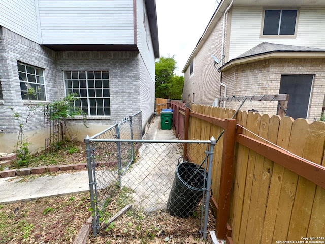 10511 Pemspice, San Antonio, TX 78240 - view of side of home with brick siding, a fenced backyard, and a gate