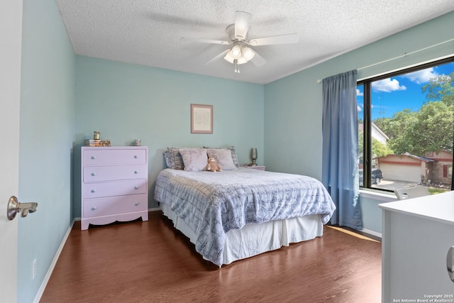 7705 Wood Blf, San Antonio, TX 78240 - bedroom featuring dark wood-style flooring, a textured ceiling, baseboards, and ceiling fan
