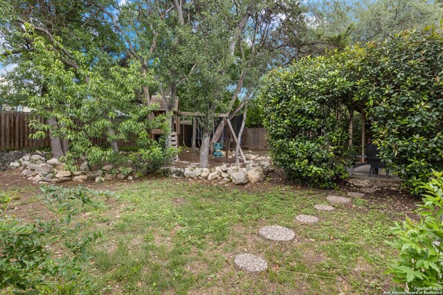 7705 Wood Blf, San Antonio, TX 78240 - fenced backyard featuring a playground