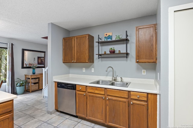 7705 Wood Blf, San Antonio, TX 78240 - kitchen with stainless steel dishwasher, a sink, a textured ceiling, light countertops, and light tile patterned floors