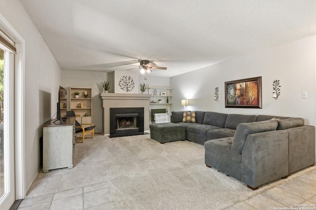 7705 Wood Blf, San Antonio, TX 78240 - living area with ceiling fan, a textured ceiling, a fireplace with flush hearth, light colored carpet, and light tile patterned floors
