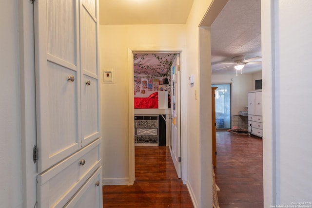 corridor with dark wood-style floors and baseboards